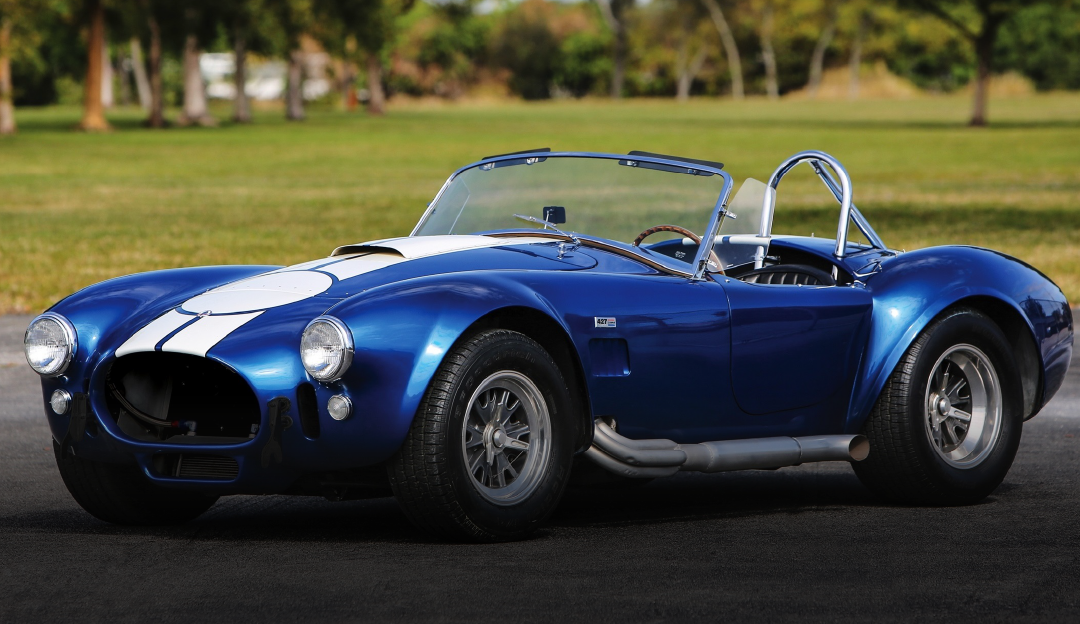 A blue and white sports car is parked on the side of the road.