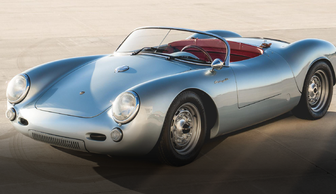 A silver sports car with a red seat is parked on the side of the road.