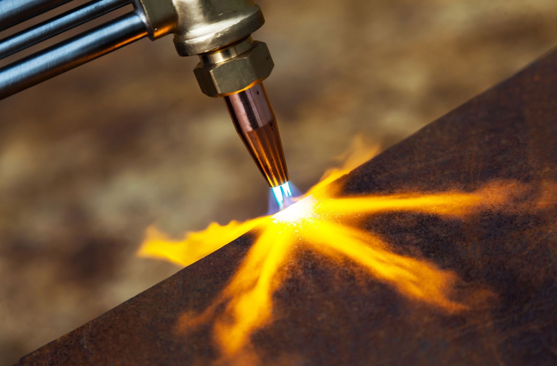 A close up of a torch cutting a piece of metal