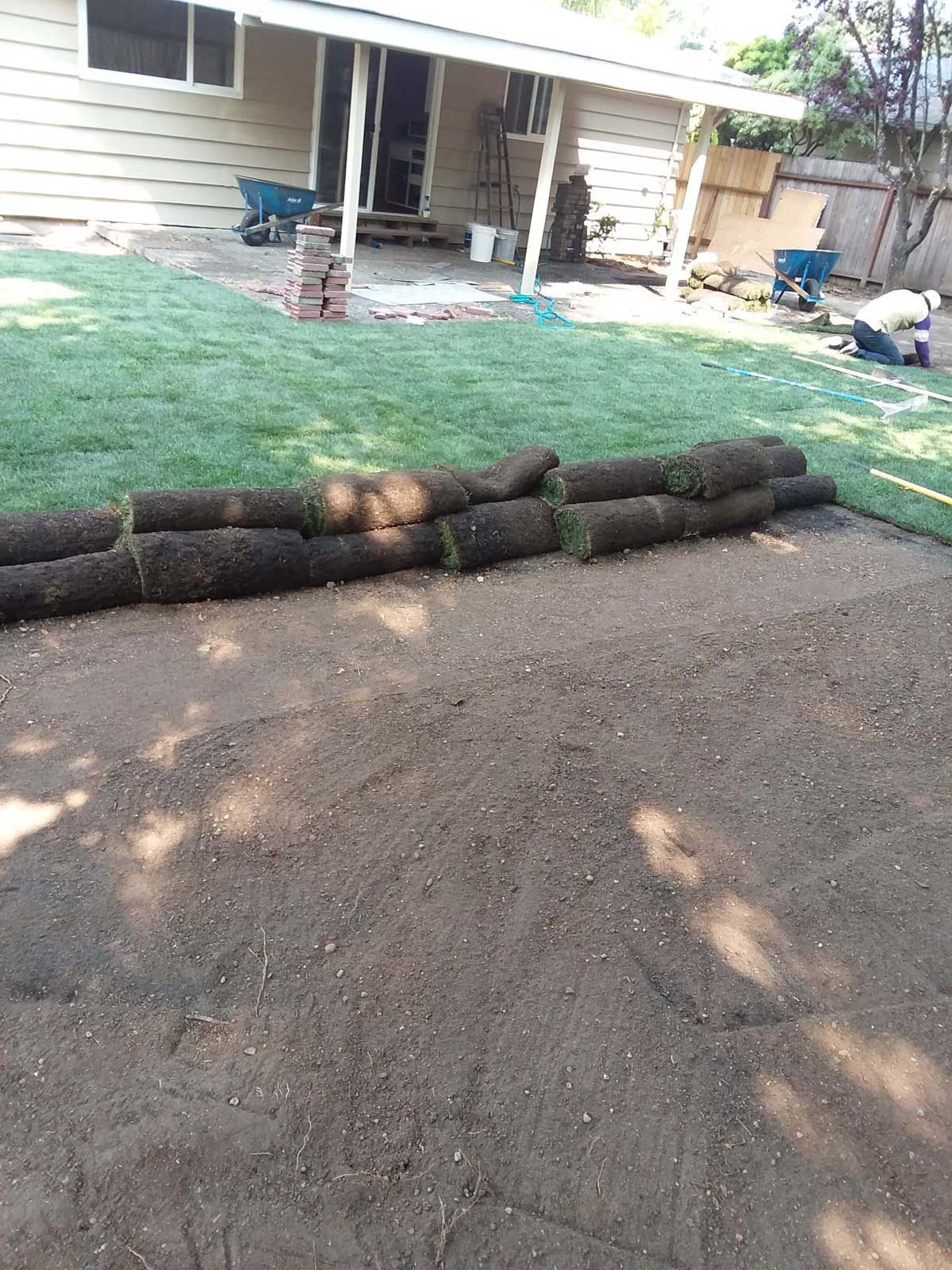 A lawn is being installed in front of a house.