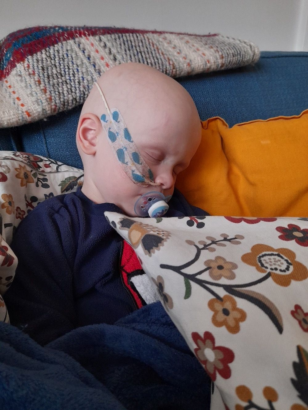 Website Sorted Three Peaks Challenge | A baby with a pacifier in his mouth is sleeping on a couch