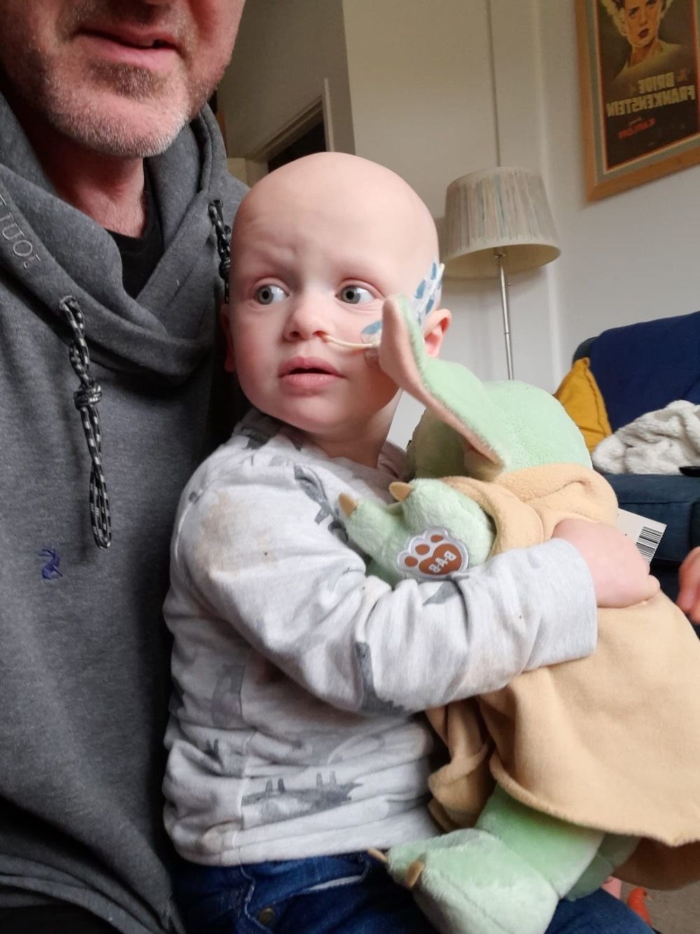 Website Sorted Three Peaks Challenge | A man is holding a baby with a tube in his nose