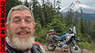 Bearded man on motorcycle; mountain background, red road text 