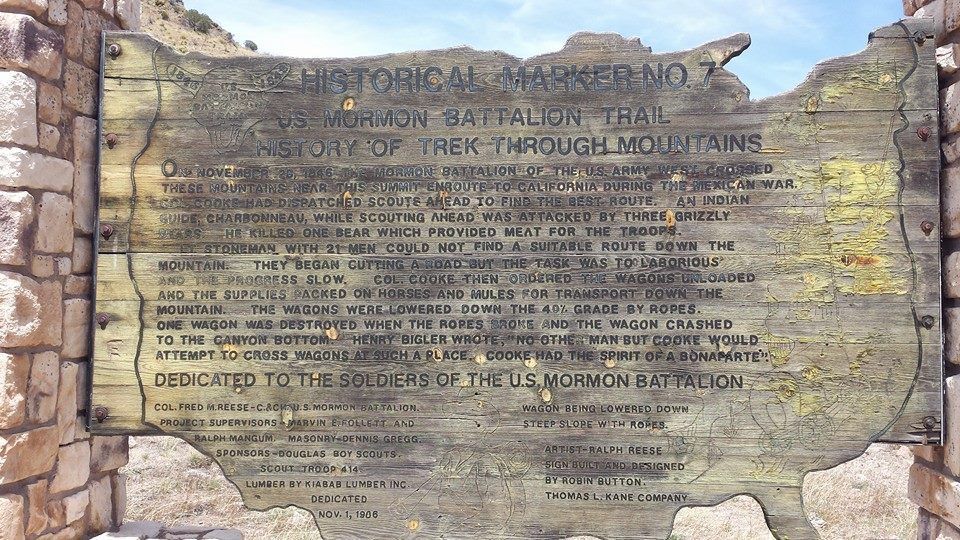 Historical marker shaped like the U.S., weathered, with text about the Mormon Battalion trail.