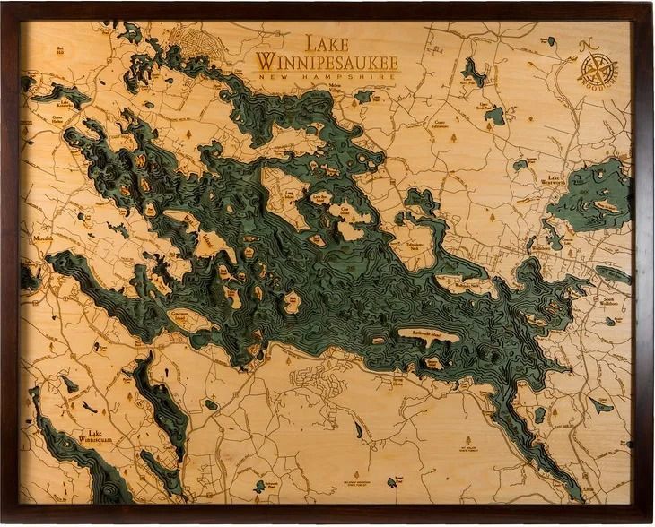 Wood-carved map of Lake Winnipesaukee, New Hampshire, with the lake in dark green and surrounding areas in natural wood tones.