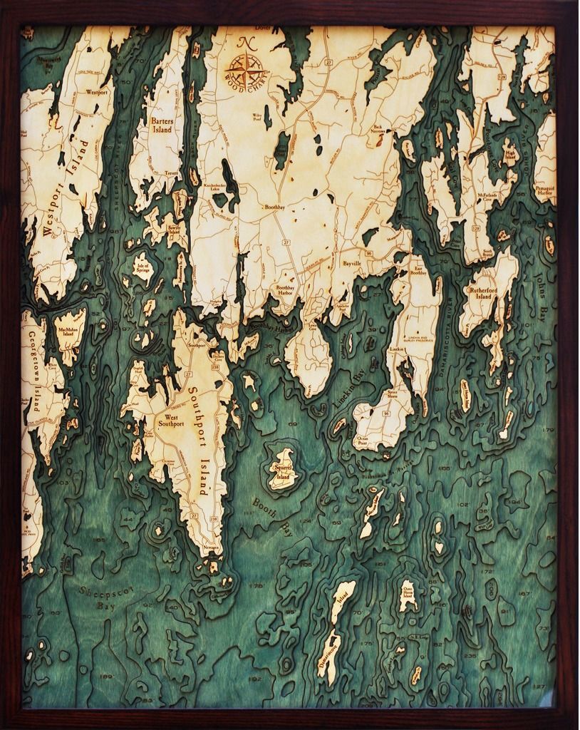 Wooden map of a coastal area, showing topography with layers of green and tan wood. Framed.