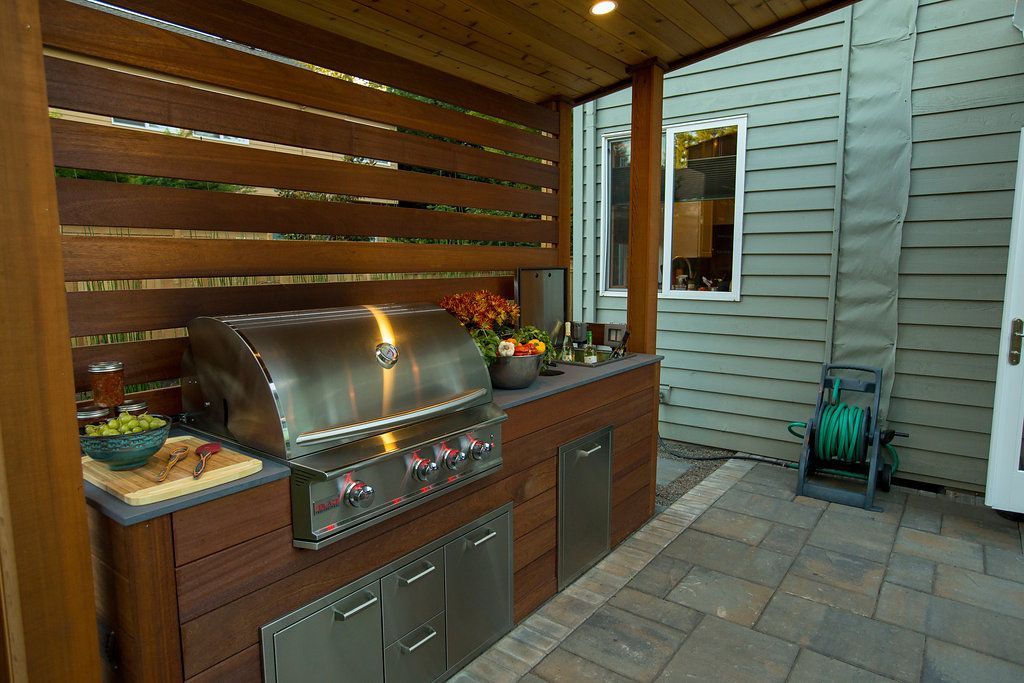 Outdoor kitchen with grill and storage, under an overhead structure in Central Point, Oregon.