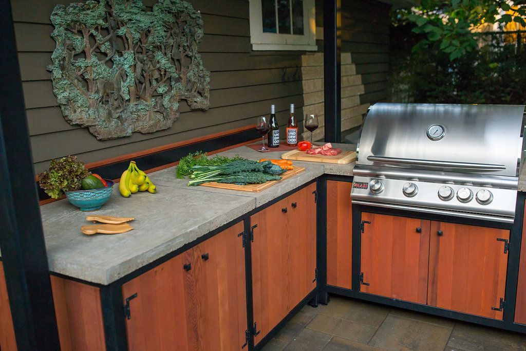 Industrial-looking outdoor kitchen with grill and metal-framed overhead structure in Ashland, Oregon.