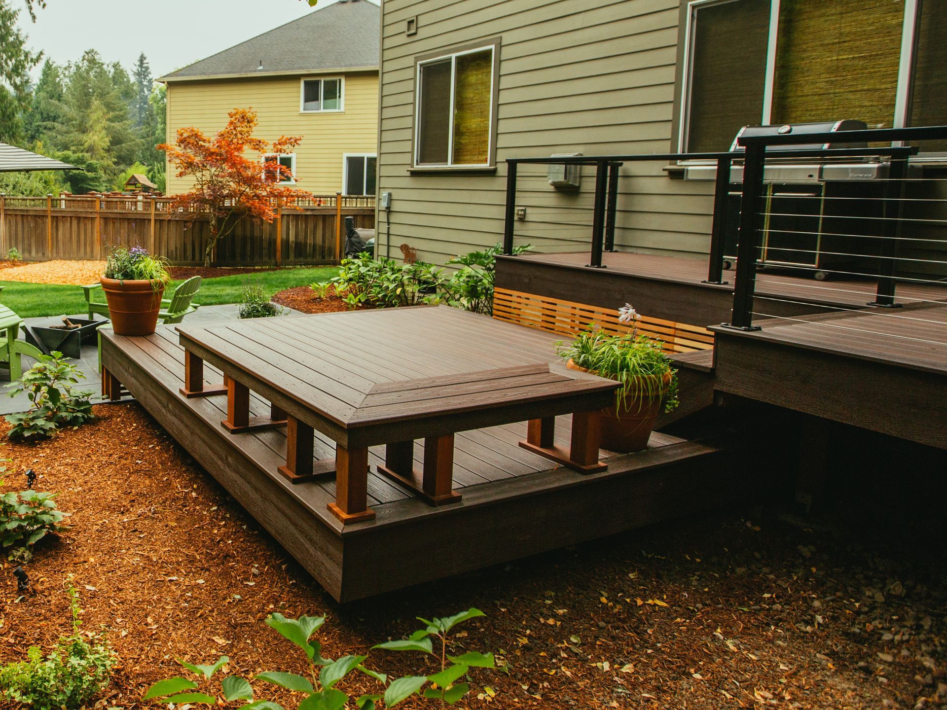 A wooden deck with a table on it in front of a house