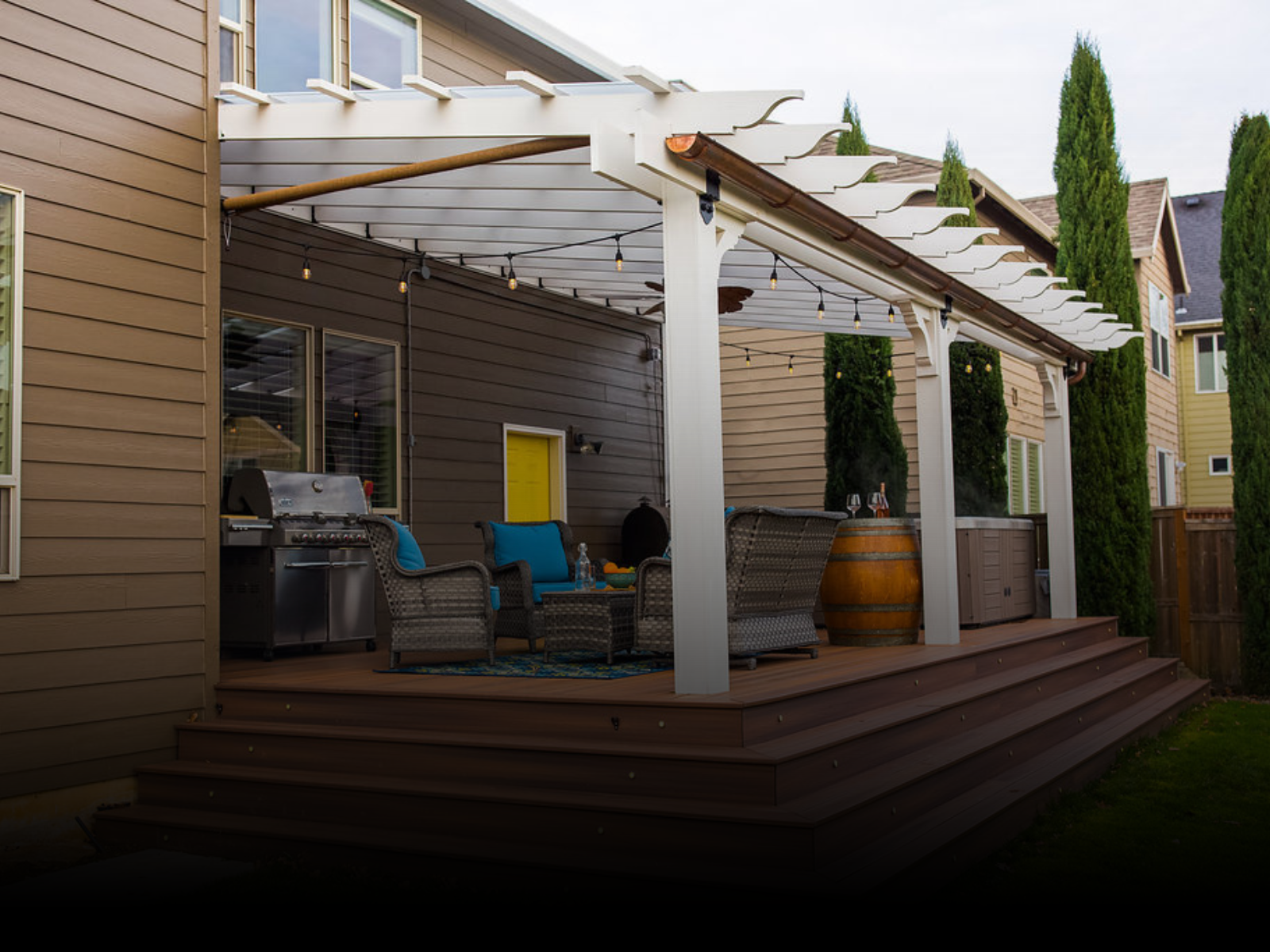 A house with a pergola and a grill on the deck