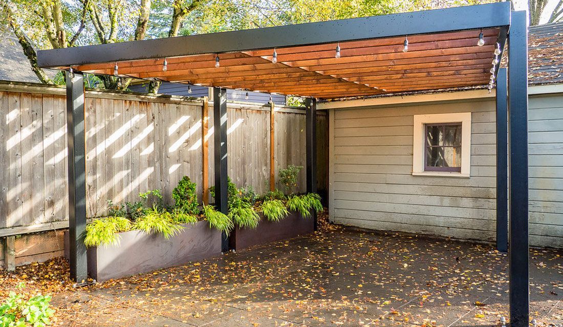 There is a pergola in the backyard of a house.