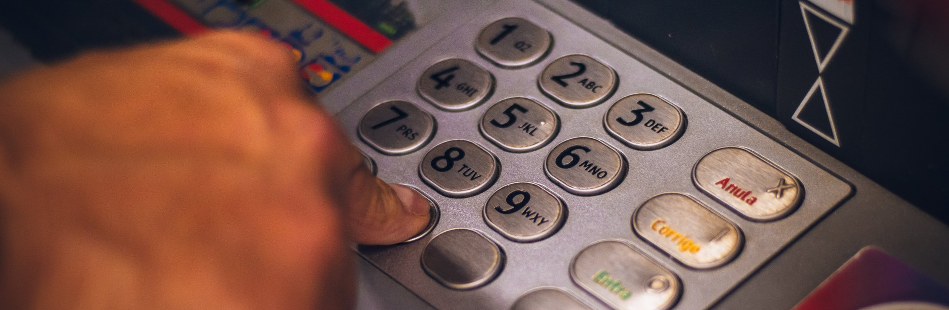 hand pressing buttons on an ATM