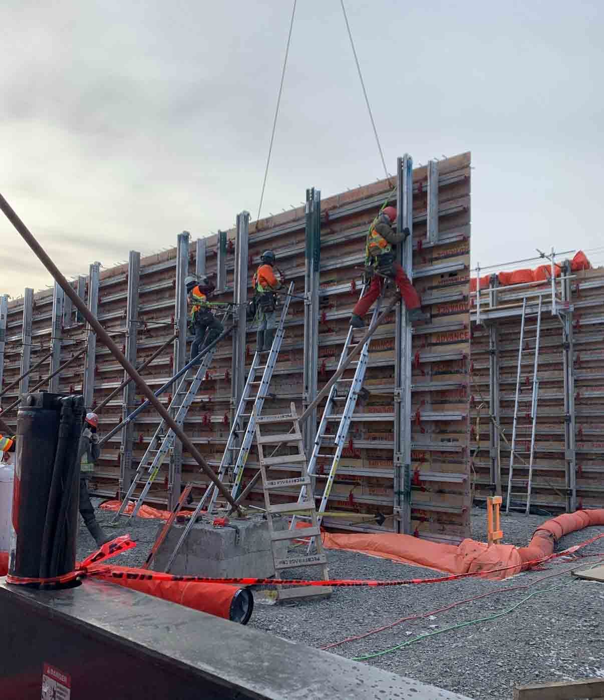 Ouvriers du bâtiment travaillant avec des coffrages en bois et en métal. À l'intérieur d'un bâtiment, ils forment une structure en béton.