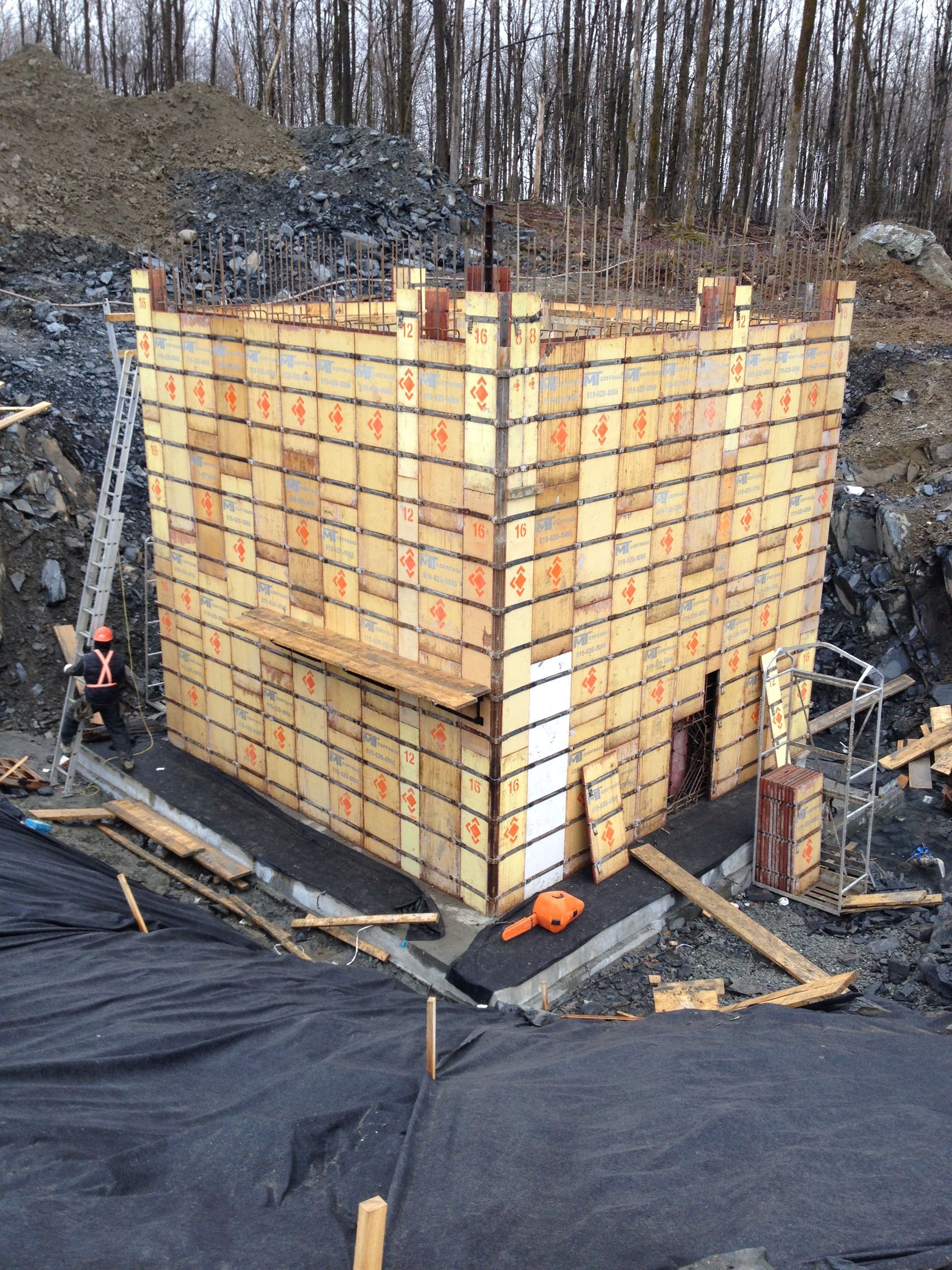 Structure de coffrage en bois sur un chantier de construction, probablement pour le coulage du béton.