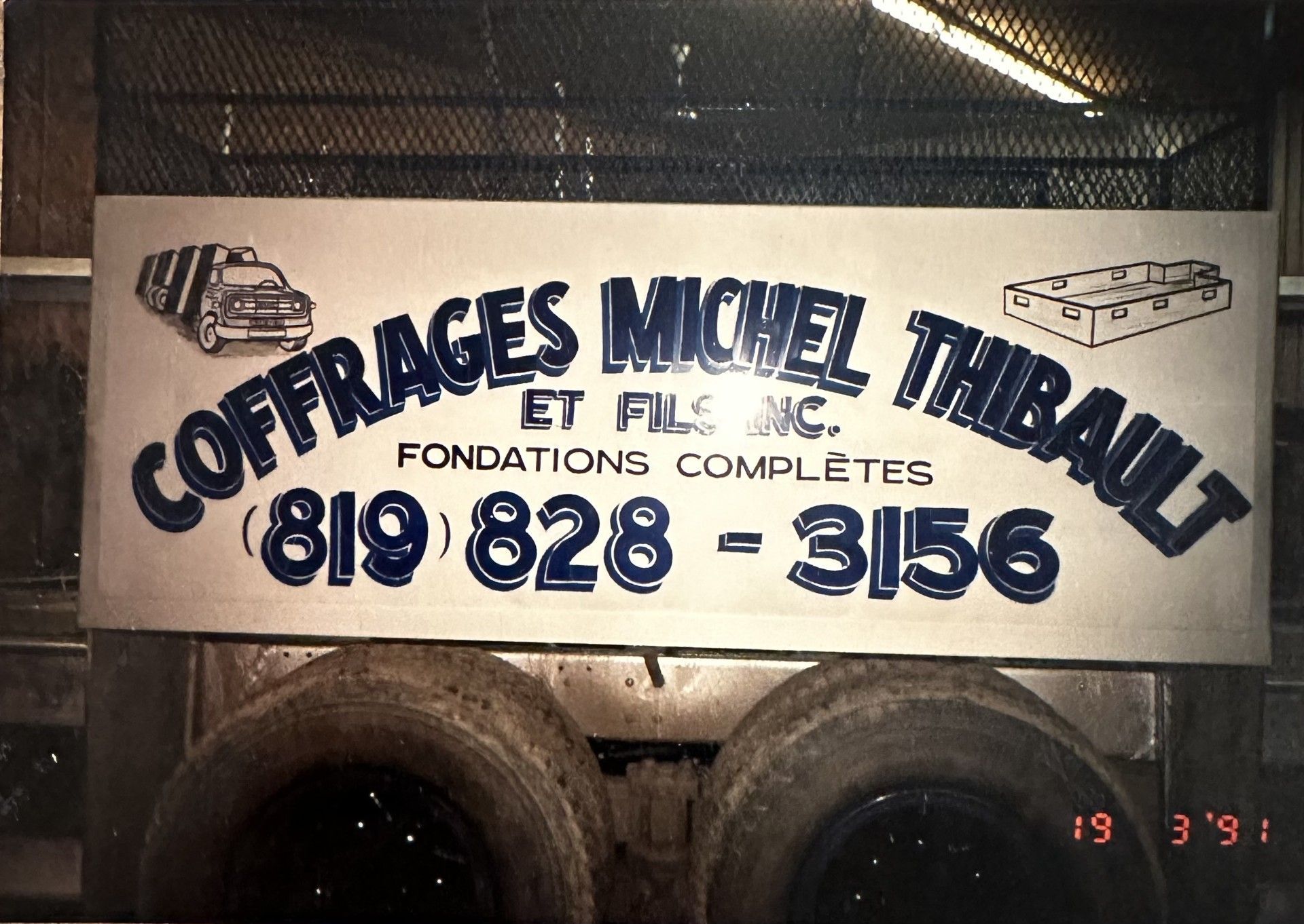 Panneau de Coffrages Michel Thibault, Inc. sur un camion. Bleu et blanc, numéro de téléphone, daté de 1991.