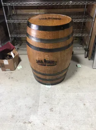 Wooden Jack Daniel’s barrel standing on a concrete floor in a storage area