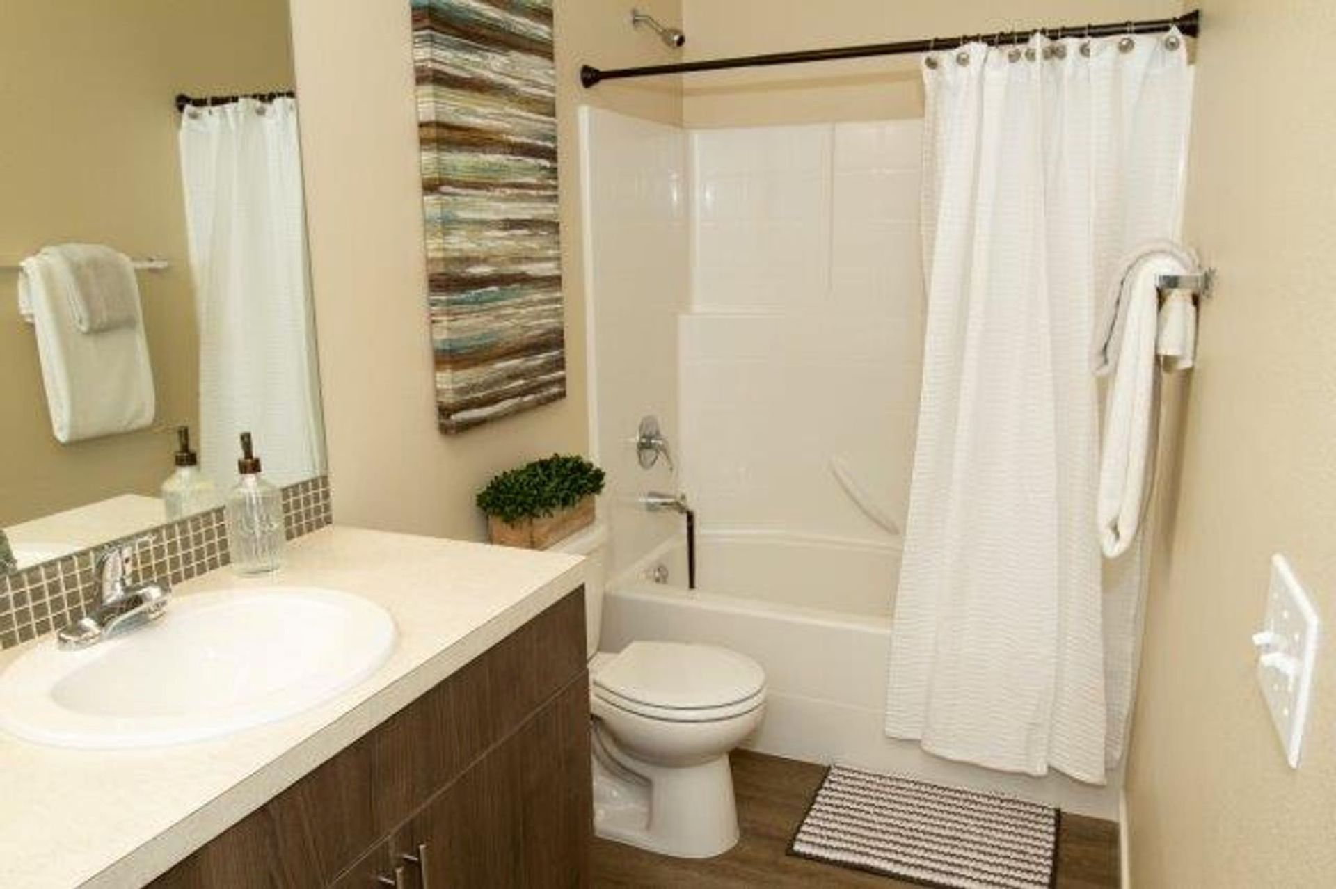 A bathroom with a toilet , sink , bathtub and shower curtain.