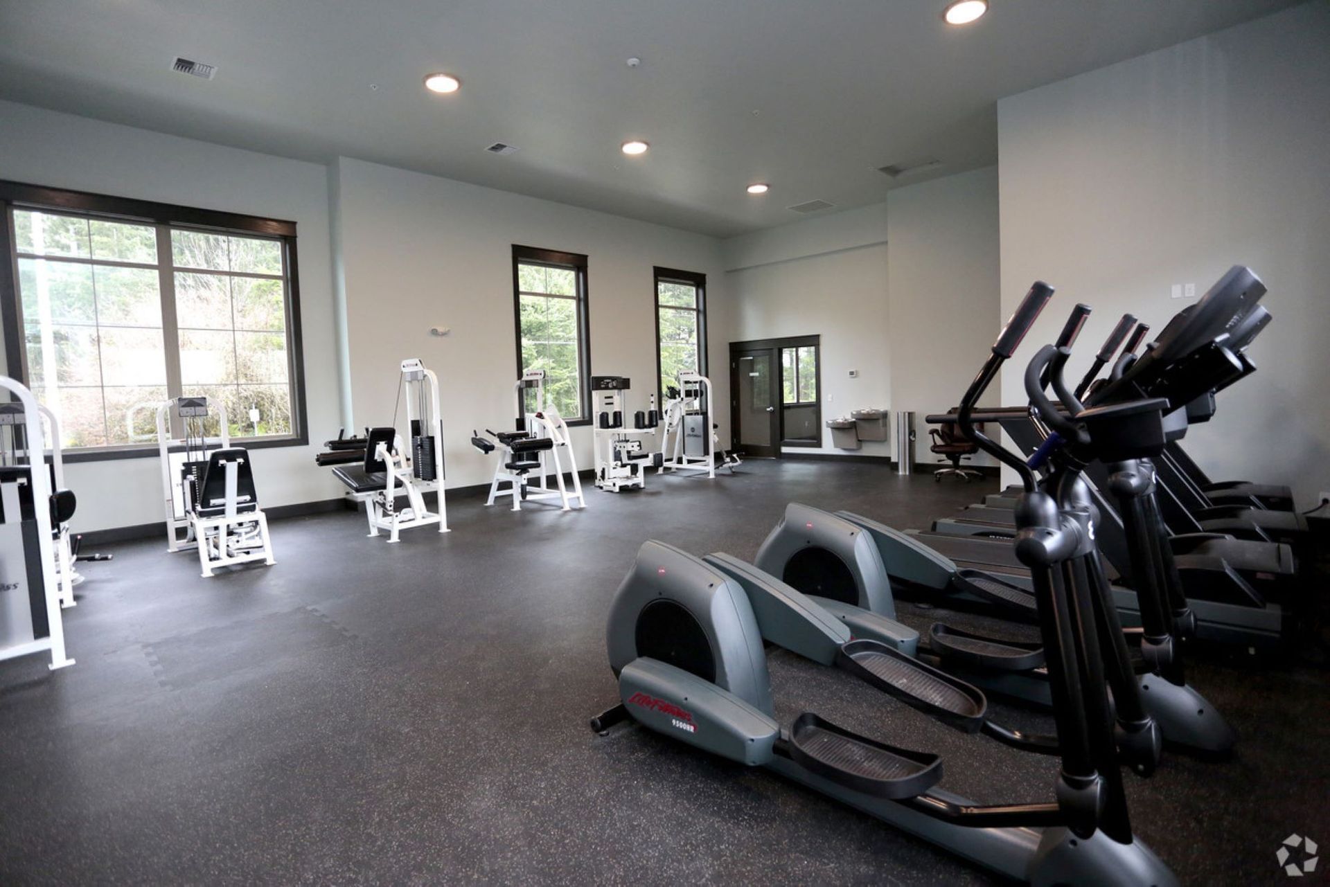 A large gym filled with lots of exercise equipment.