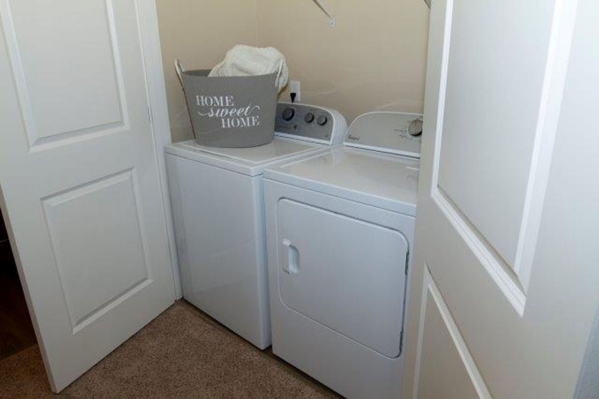 A laundry room with a washer and dryer and a laundry basket.