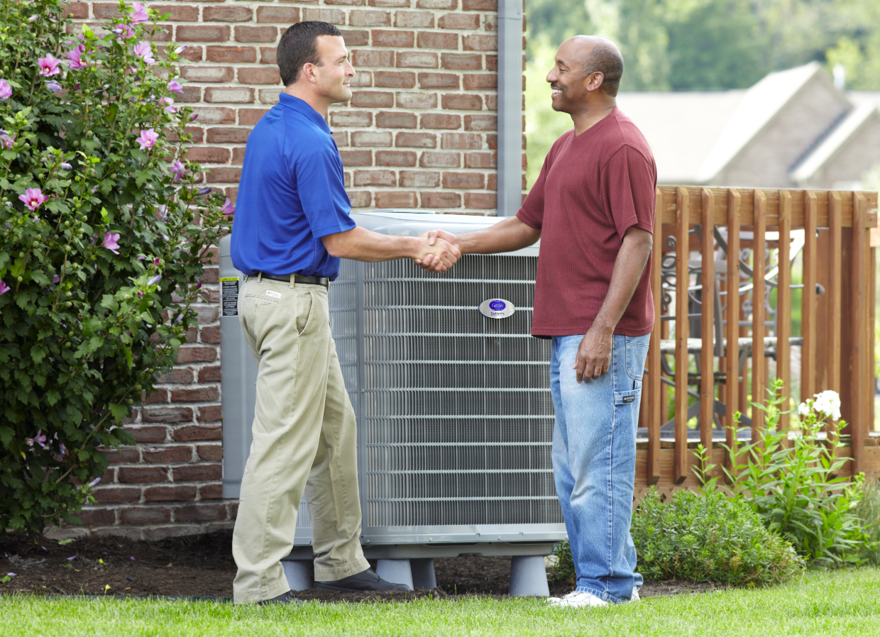 Outdoor air conditioning unit beside a house on a concrete pad