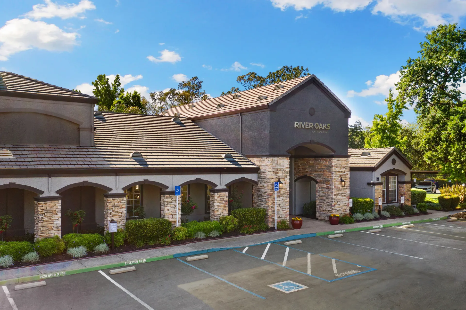 Exterior of Riverbend building with arched entrance and parking spaces at River Oaks.