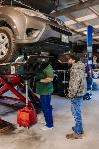 A man is working on the engine of a car.