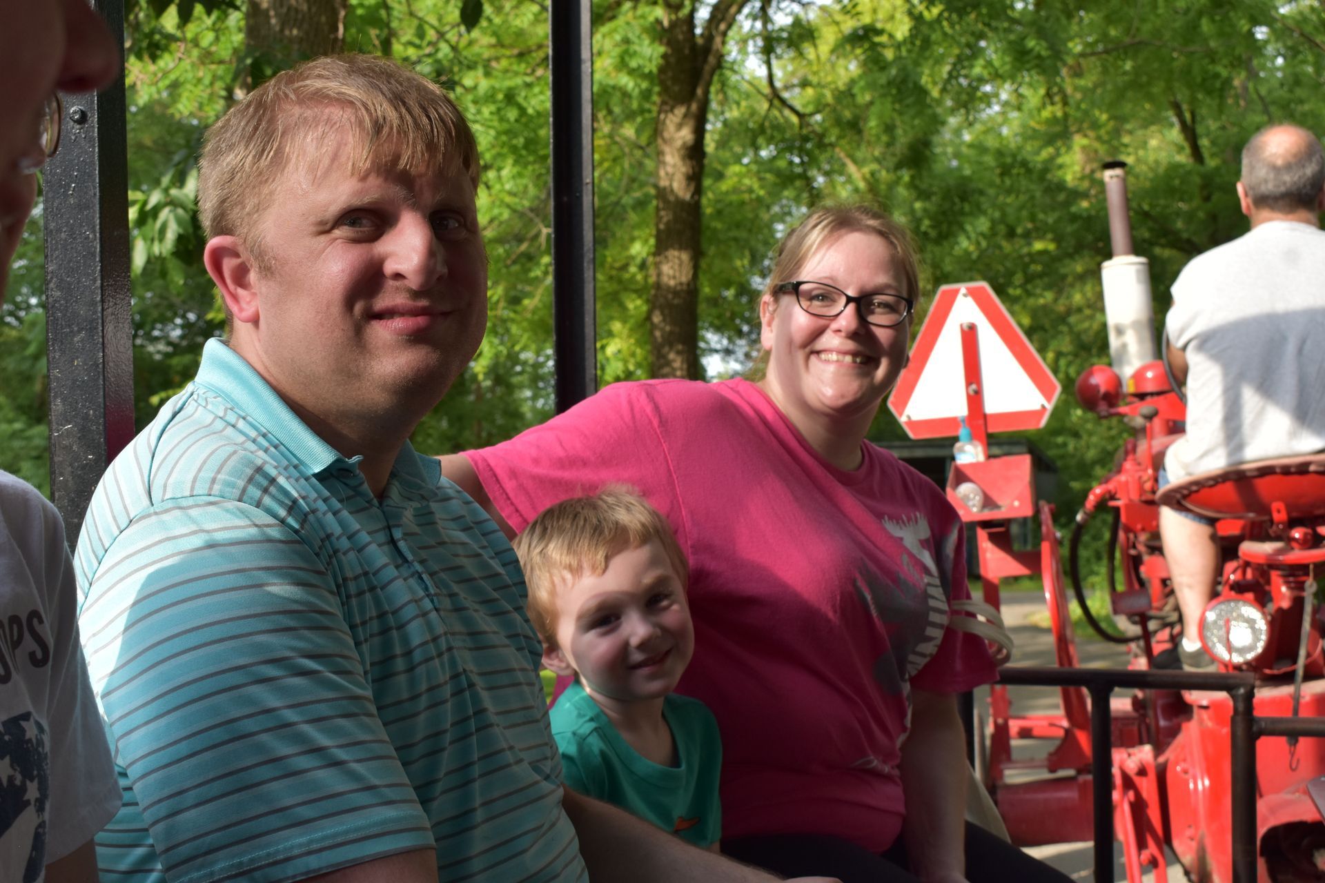 A man , woman and child are sitting on a train.