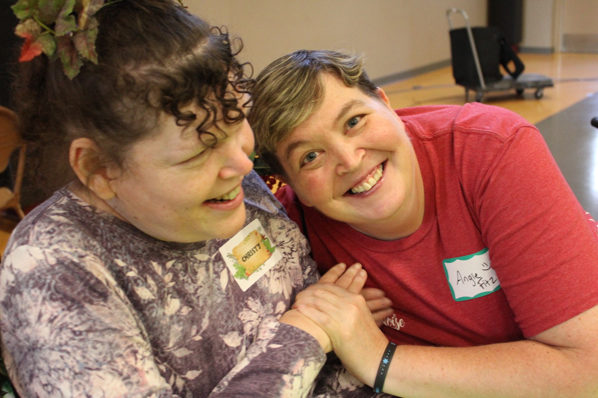 Two women are sitting next to each other and smiling for the camera.