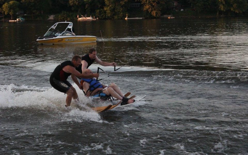 A person in a wheelchair is being towed by a boat in the water.