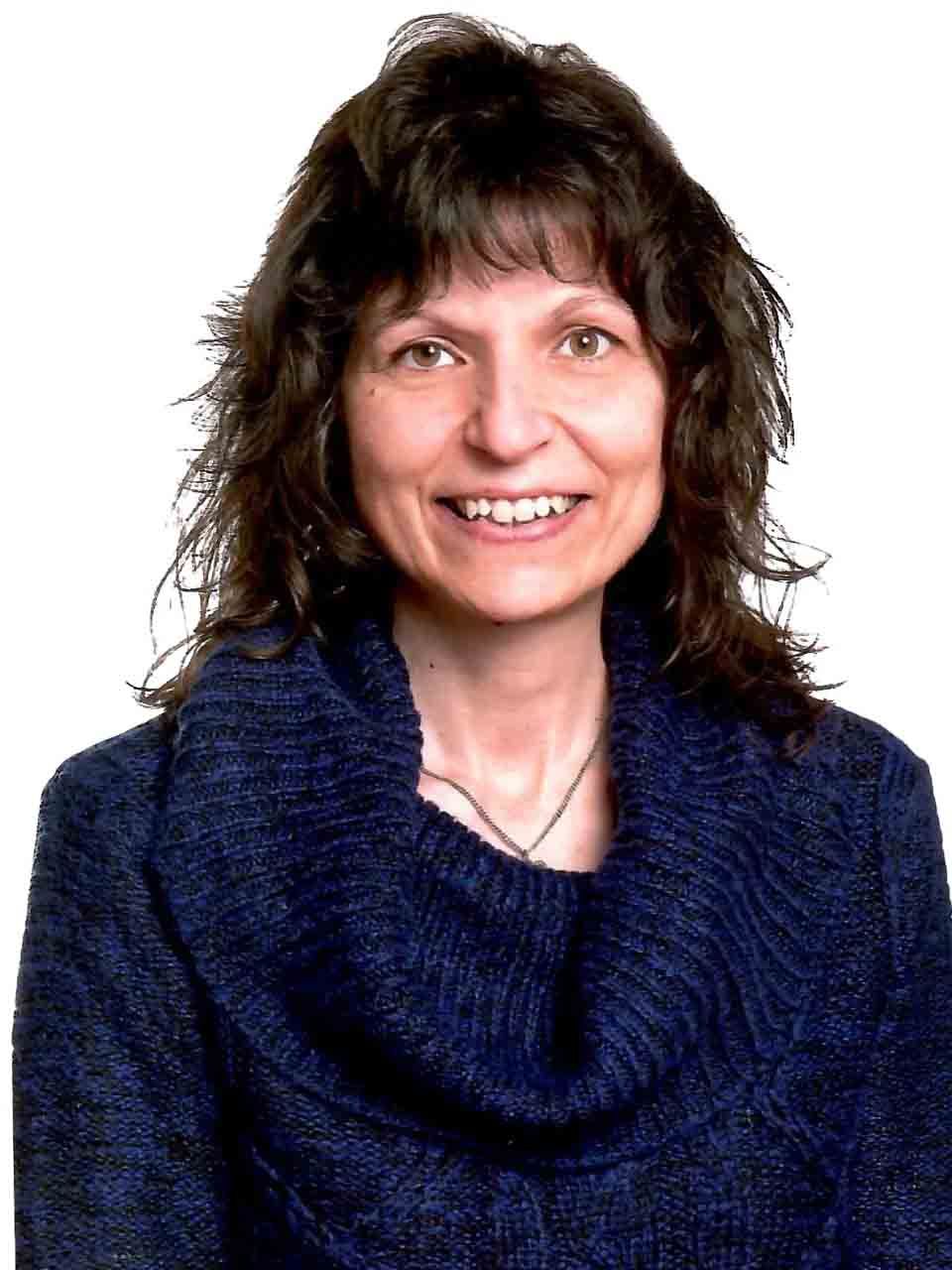 Femme en pull bleu marine souriant sur fond blanc