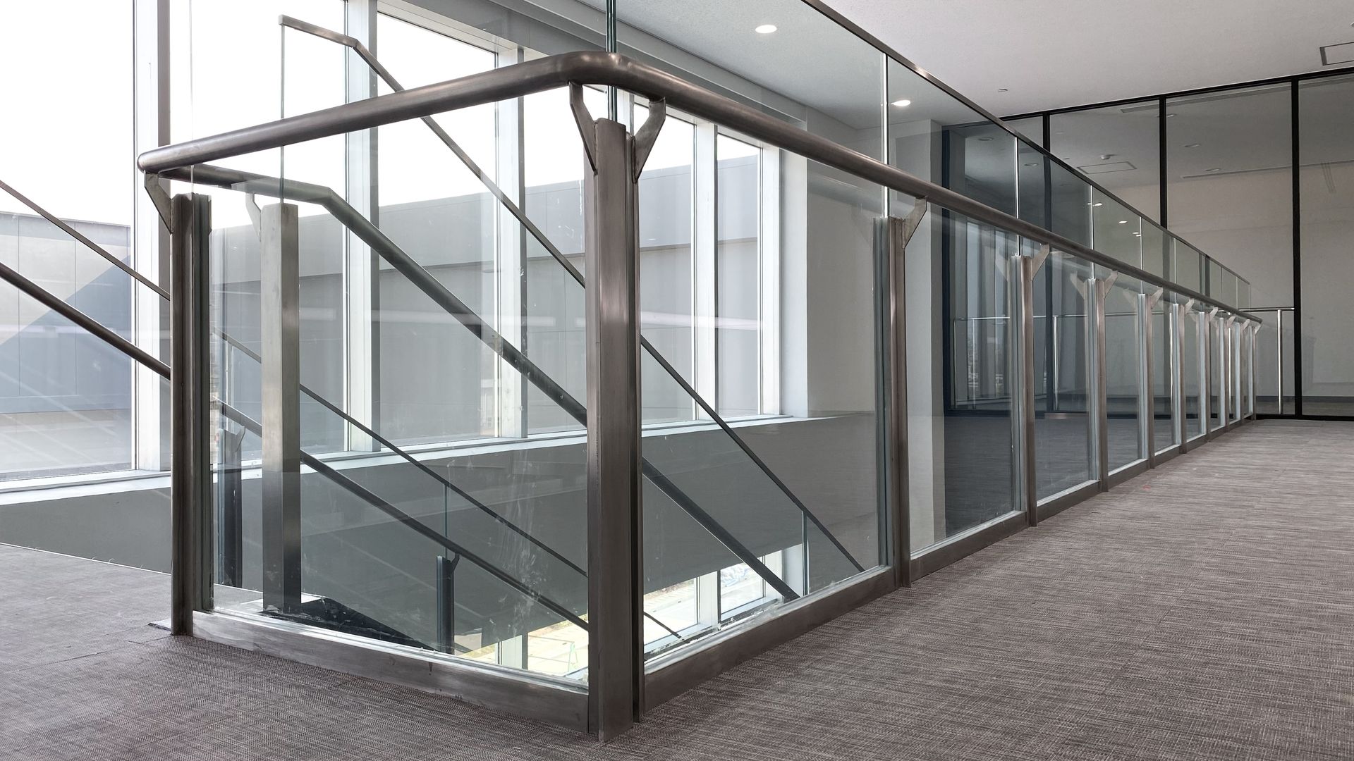 Modern glass-and-metal stairway and corridor in a bright office building