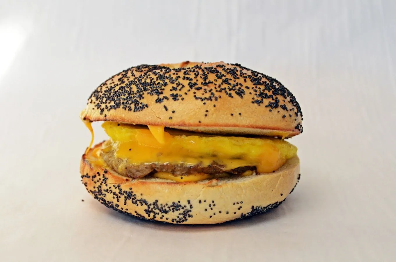 Cheeseburger on poppy seed bun, cheese melted over patty.