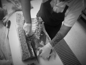  butcher cutting a large piece of meat 