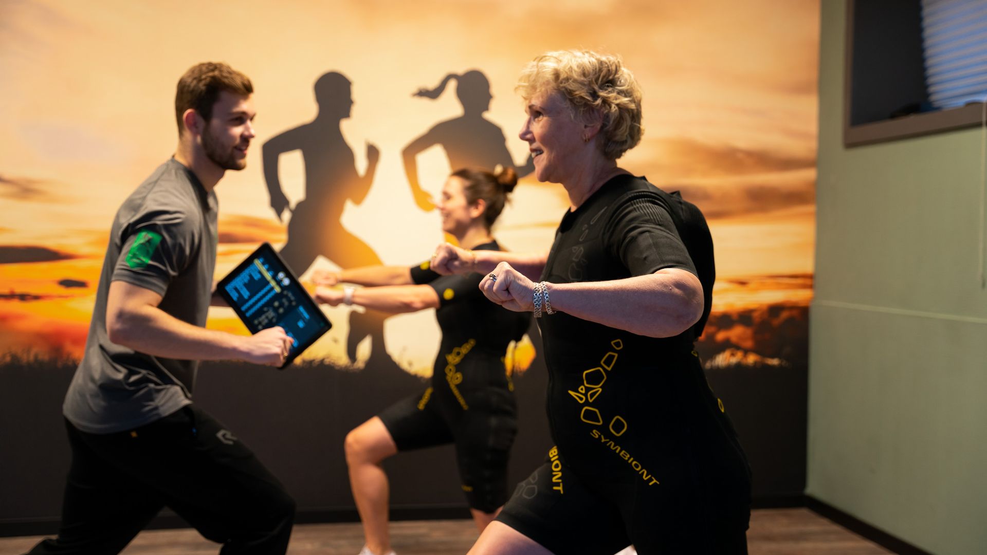 Een groep mensen doet oefeningen in een sportschool.