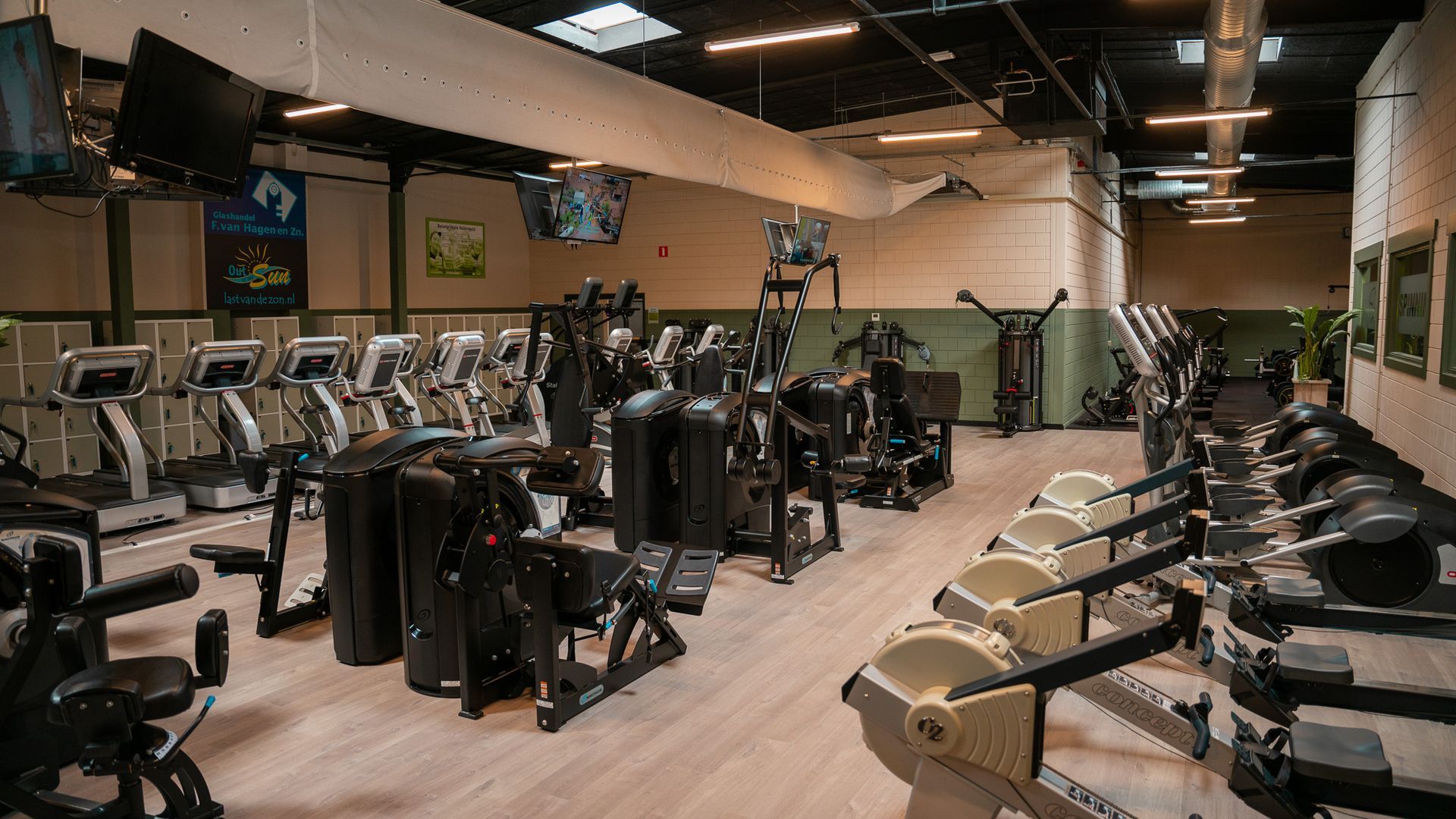 Een grote sportschool vol met fitnessapparatuur.