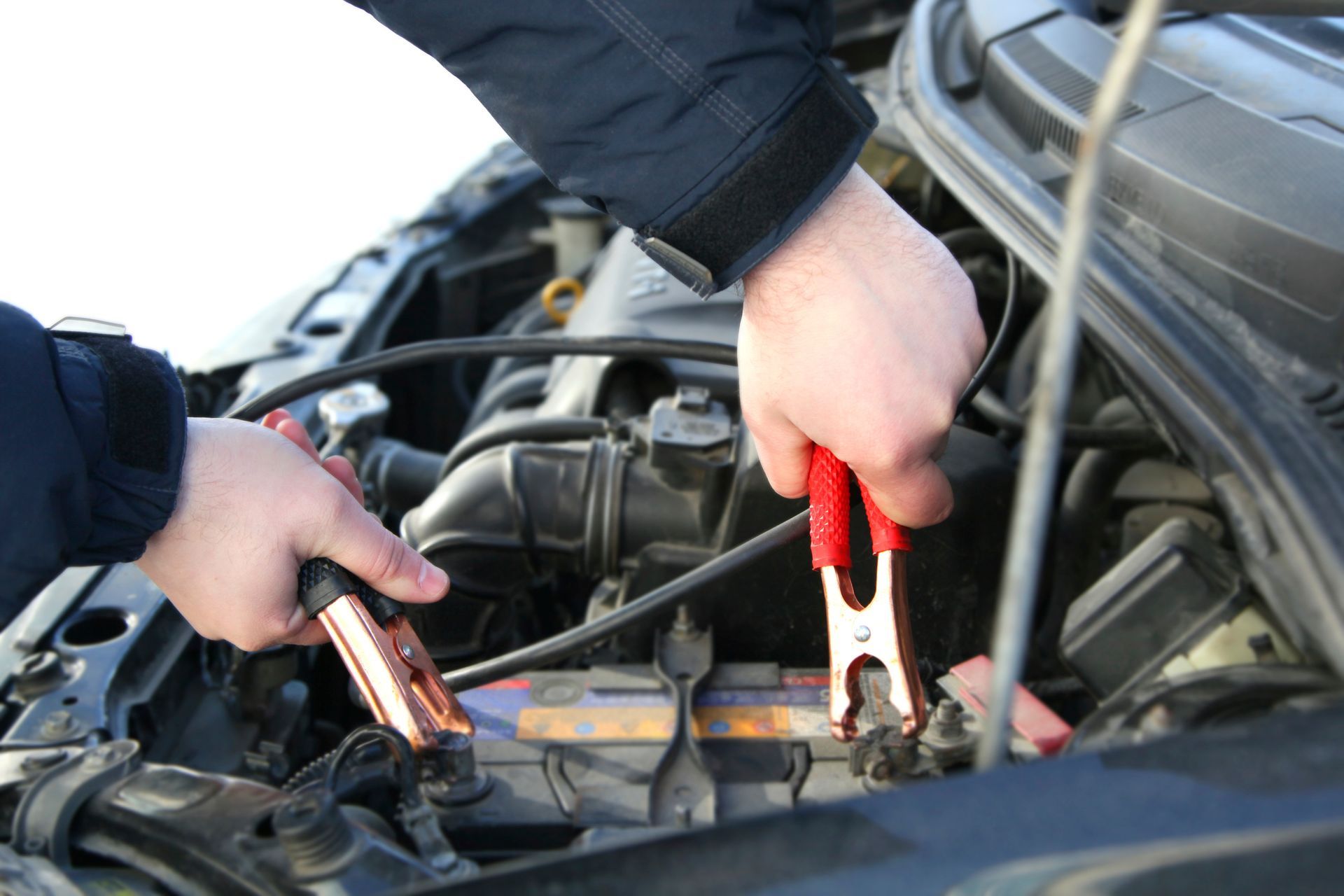 A person is charging a car battery with jumper cables.| Ruckersville, VA | KEL-CAM Tire & Auto