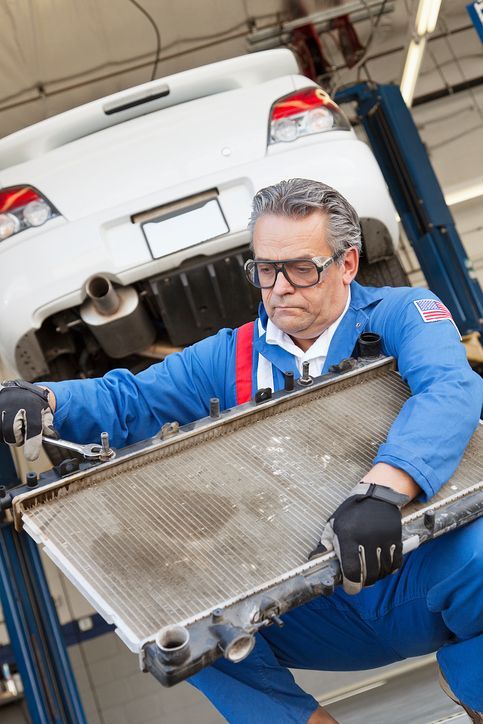 A man is working on a car radiator in a garage.| Ruckersville, VA | KEL-CAM Tire & Auto