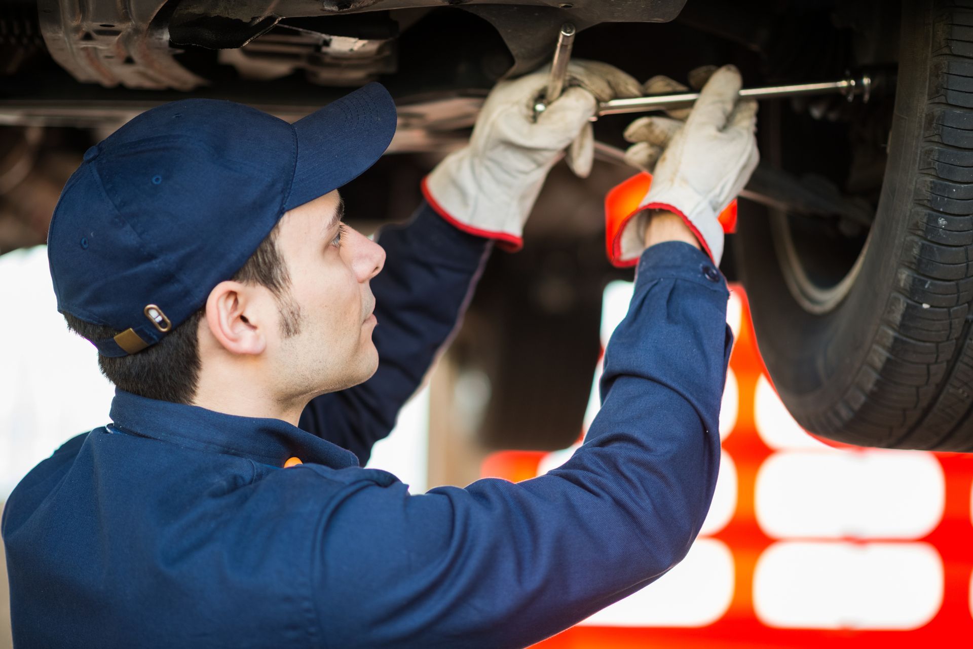 A man is working under a car with a wrench.| Ruckersville, VA | KEL-CAM Tire & Auto