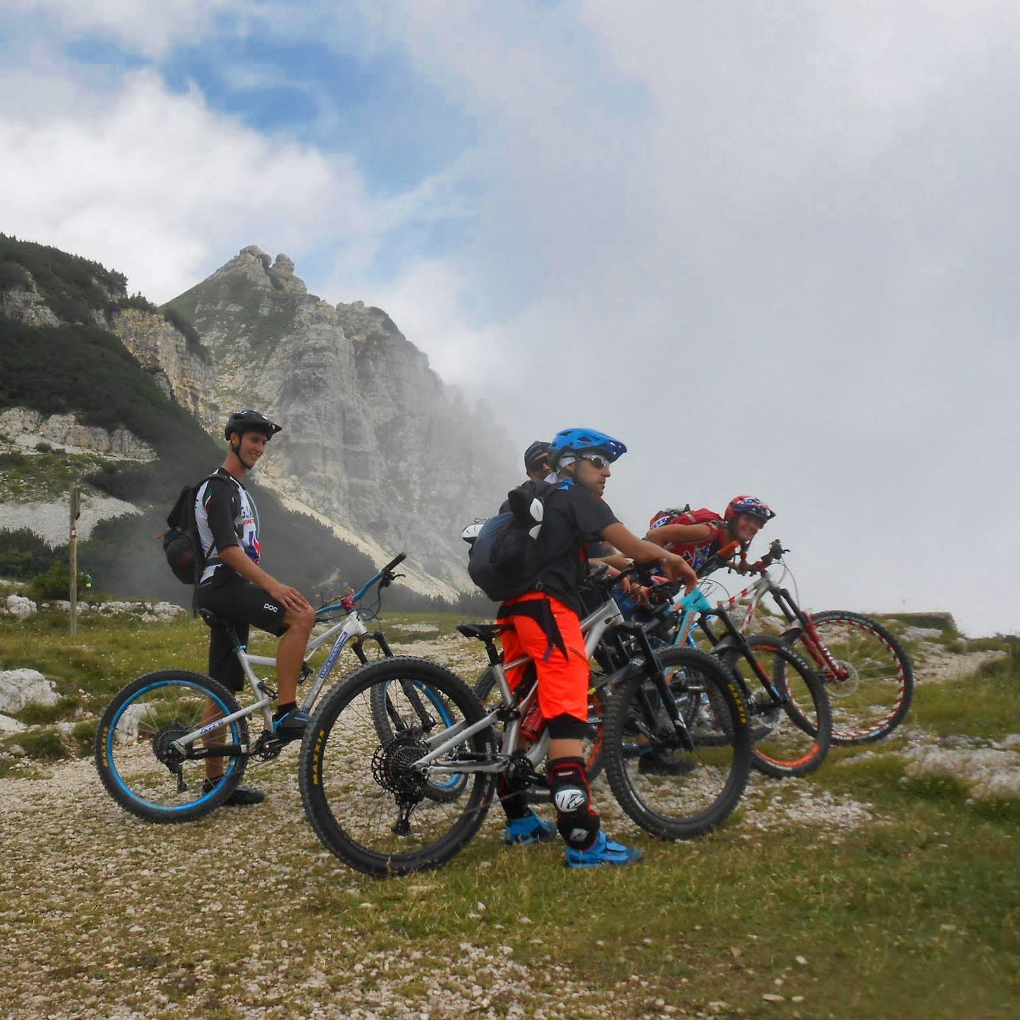 Un gruppo di persone va in bicicletta in un campo con le montagne sullo sfondo