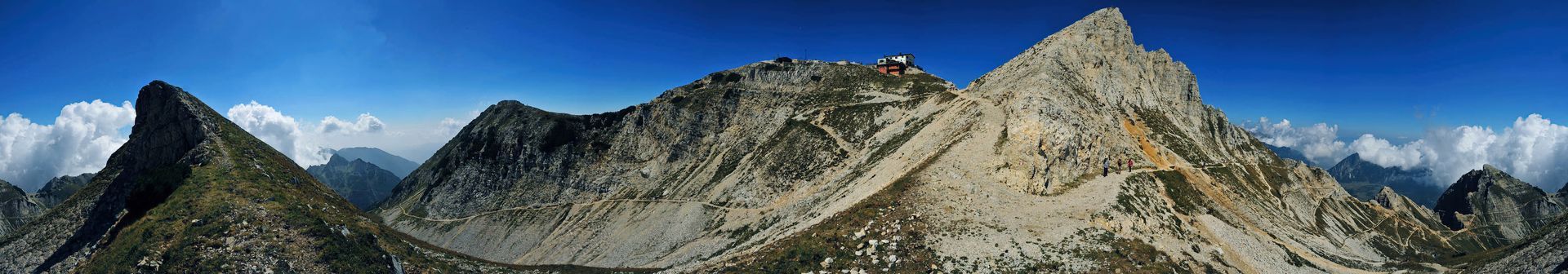 Una catena montuosa con un cielo azzurro e nuvole sullo sfondo
