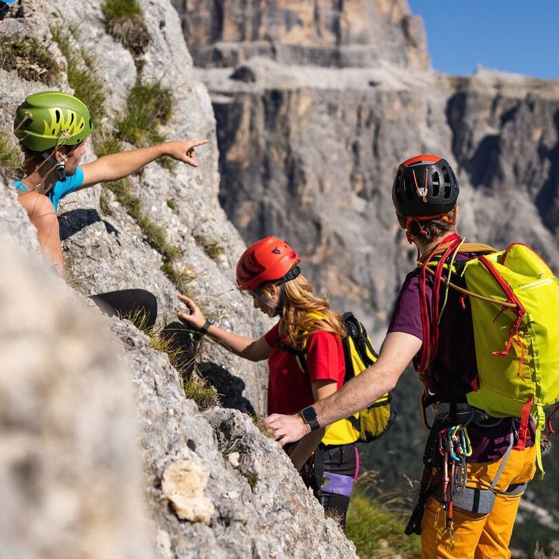 Un gruppo di persone è in piedi sulla cima di una montagna rocciosa.