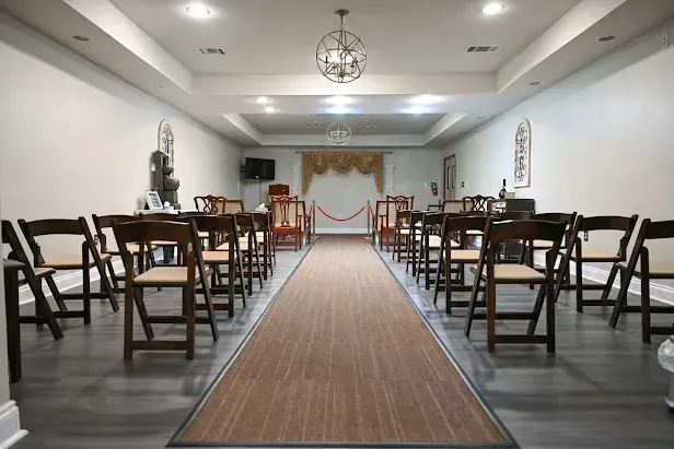 Elegant banquet hall with rows of chairs and a long aisle leading to a decorated front table