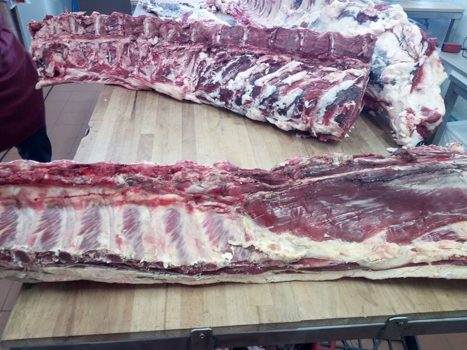 Due costine di manzo crude su un tavolo di legno, che mostrano carne e osso.