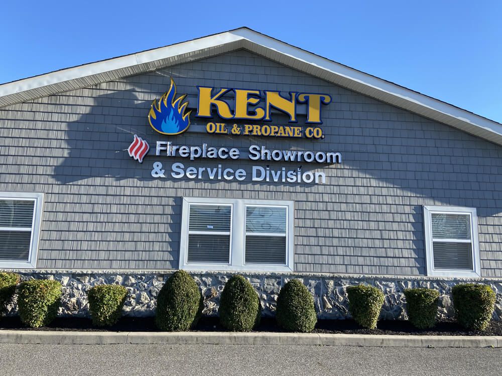 Kent Fireplace Showroom and Service Division building exterior with blue sign and gray siding