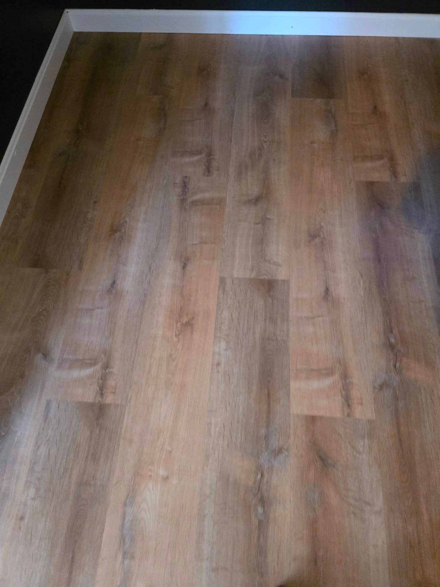 Wood-patterned laminate floor in a room, viewed from above.