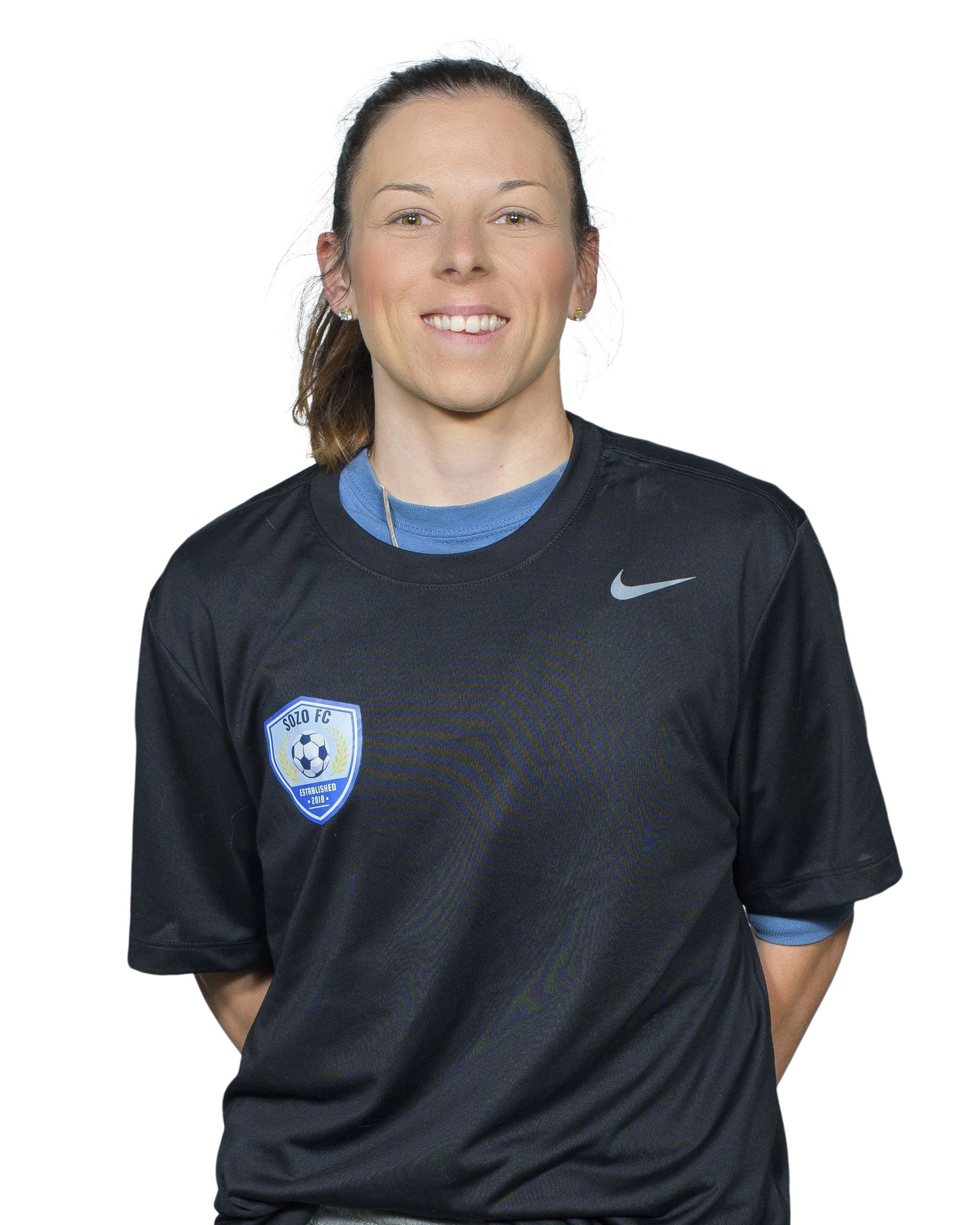 Person in a black Nike shirt, standing and smiling against a plain white background.