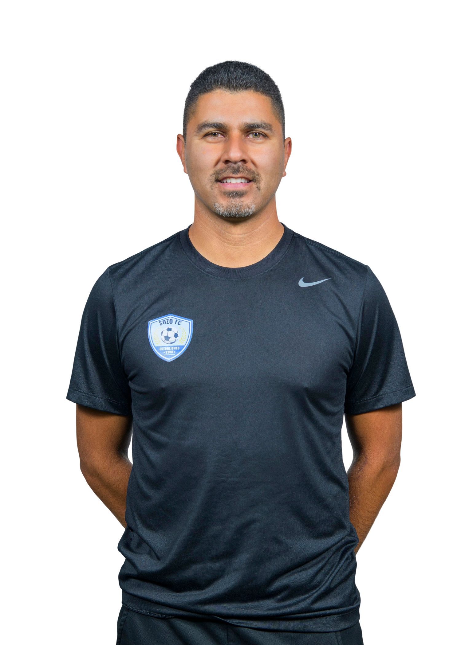A man wearing a gray polo shirt is smiling for the camera.