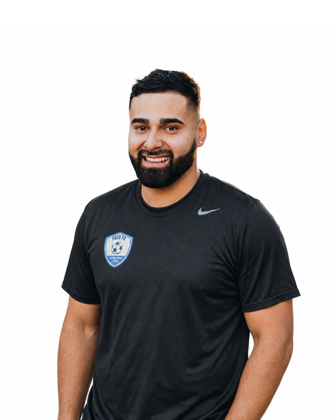 Man in a black Nike T-shirt standing against a white background, smiling at the camera.