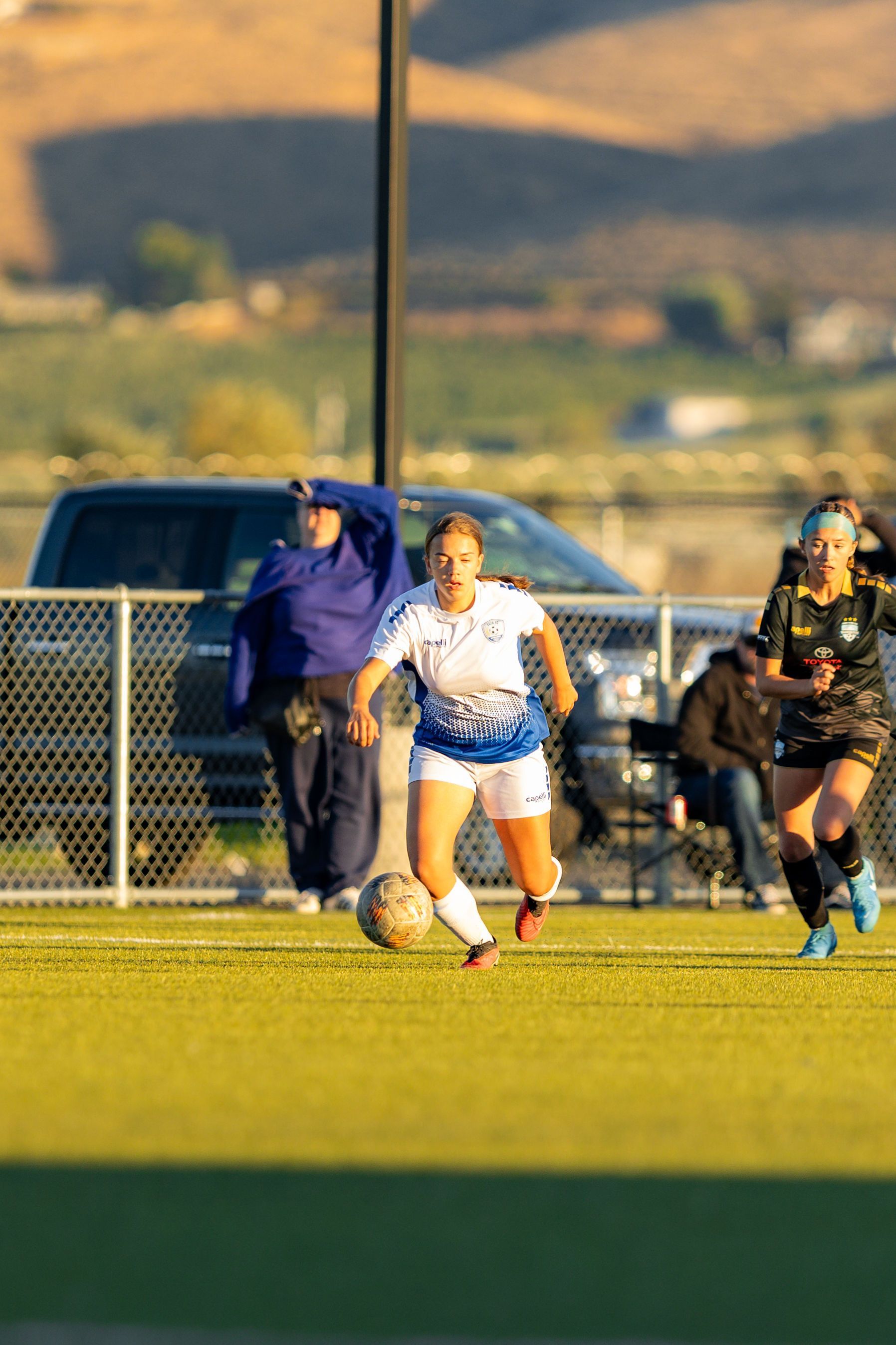 A group of women are playing soccer on a field.