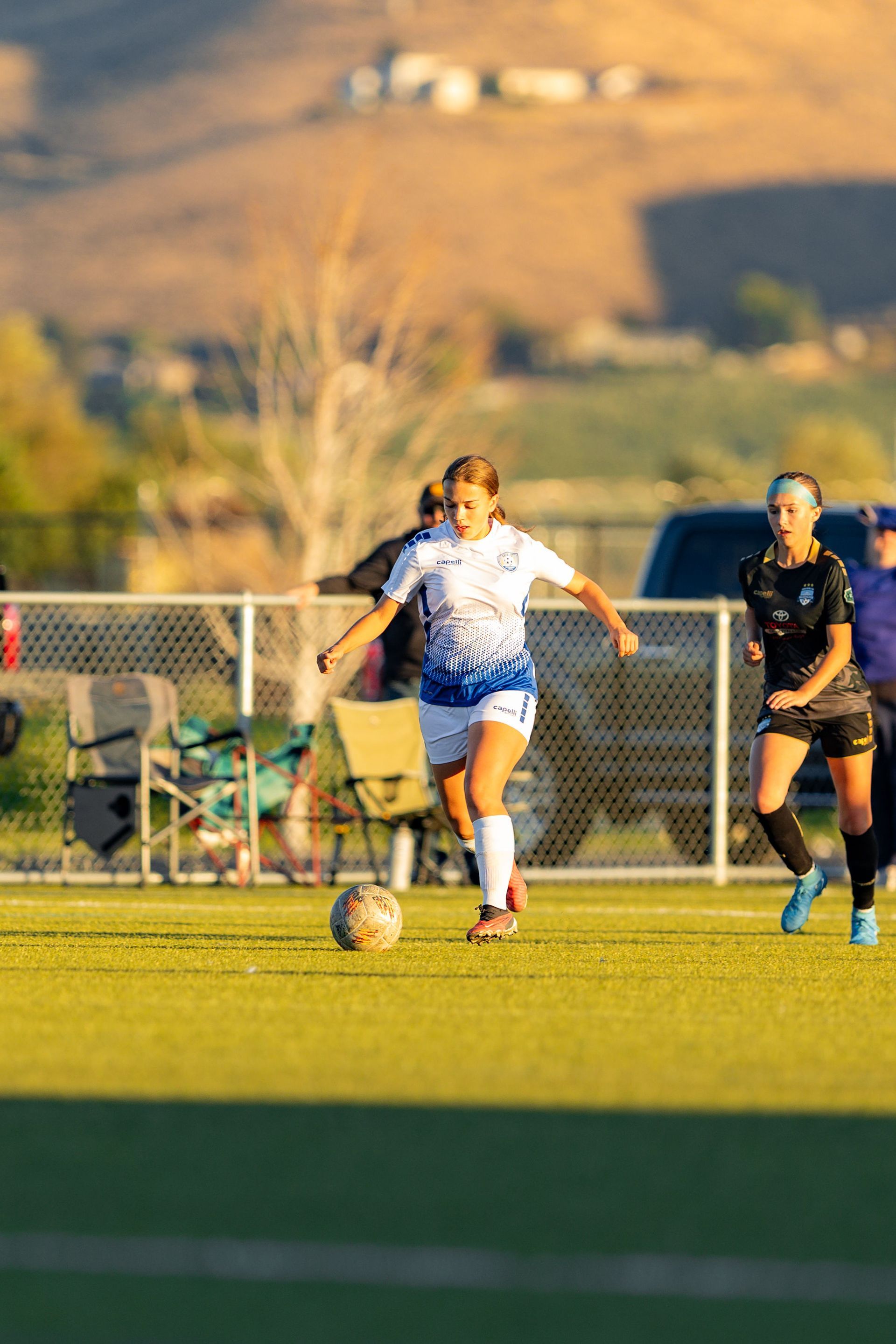 A group of women are playing soccer on a field.